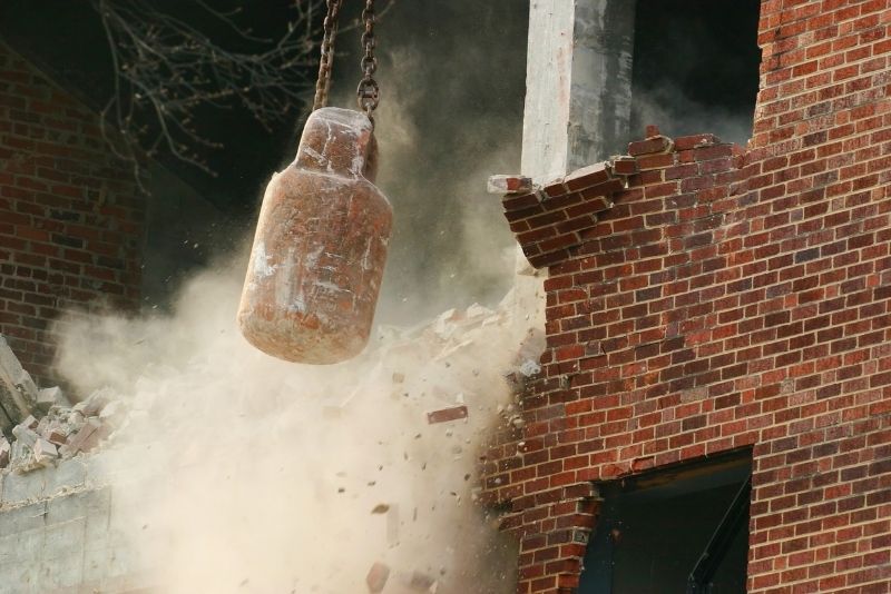 wrecking ball knocking down a building