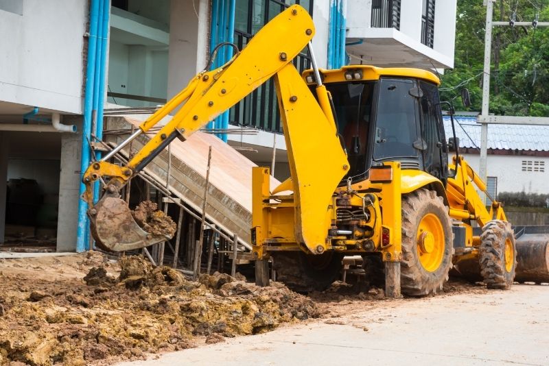 yellow excavator scooping earth