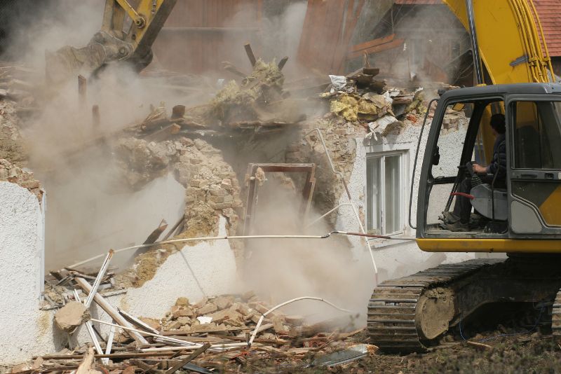 building being taken down with an excavator