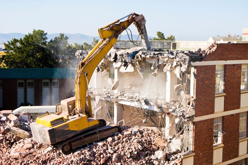 storey building being demolished by an excavator