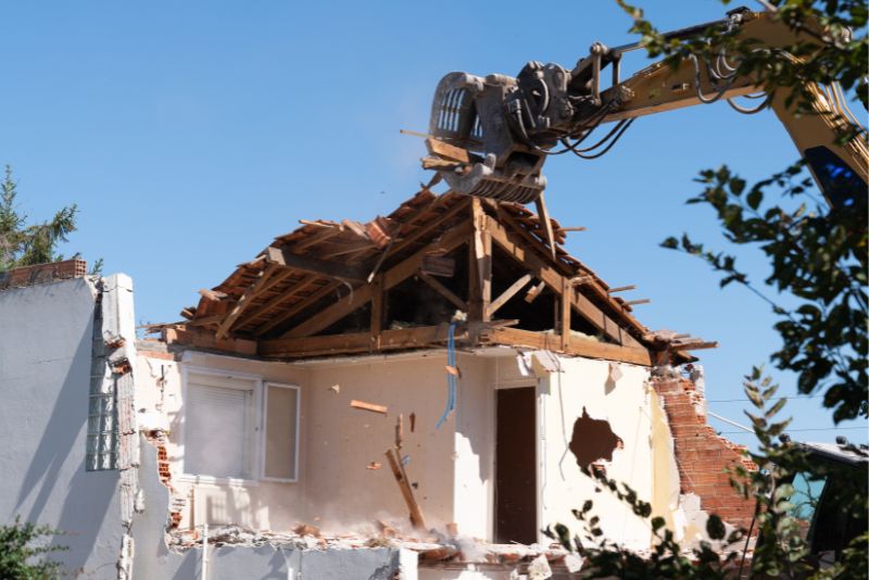 an excavator demolishing a house