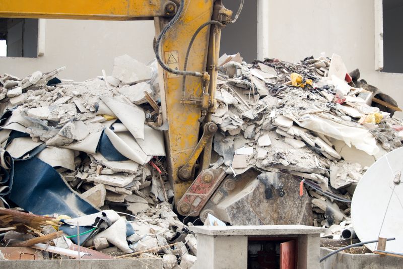 excavator scooping a pile of debris